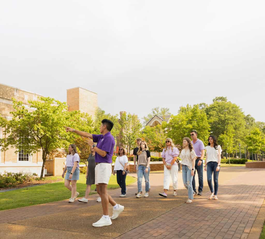 Community outdoor tour with diverse group of people in a park setting.